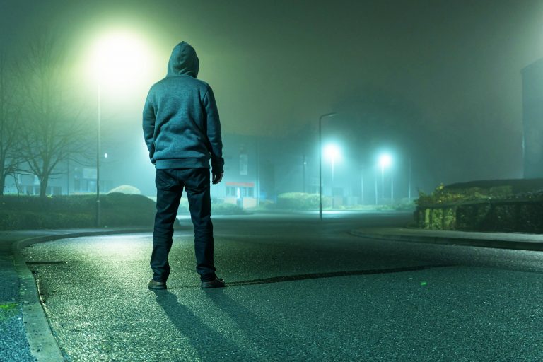 Young man standing in the street at night